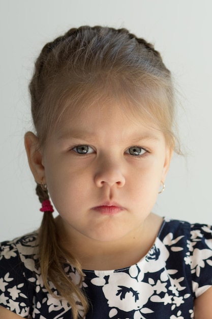 Ritratto di una bambina caucasica seria di quattro anni che guarda l'obbiettivo al coperto
