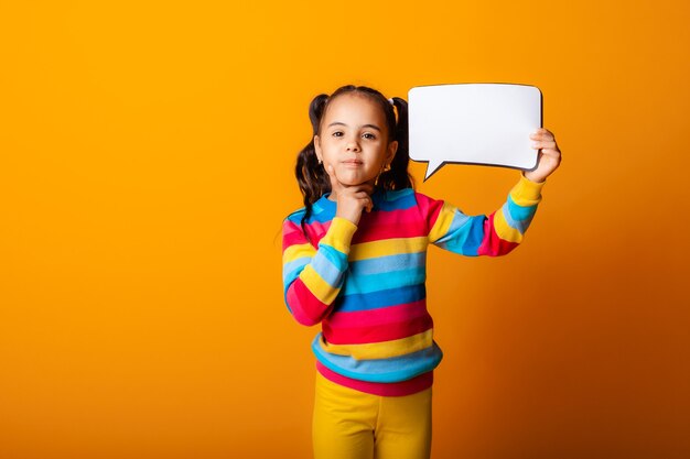 Ritratto di una bambina che tiene una nuvola di carta vuota che riflette su un'idea.