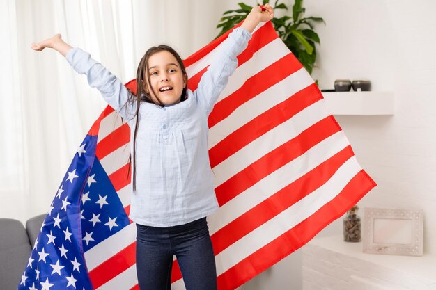 Ritratto di una bambina con la bandiera dell'America. Educazione americana, studio in America.