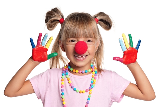 Ritratto di una bambina felice con il naso di clown rosso isolato su sfondo bianco