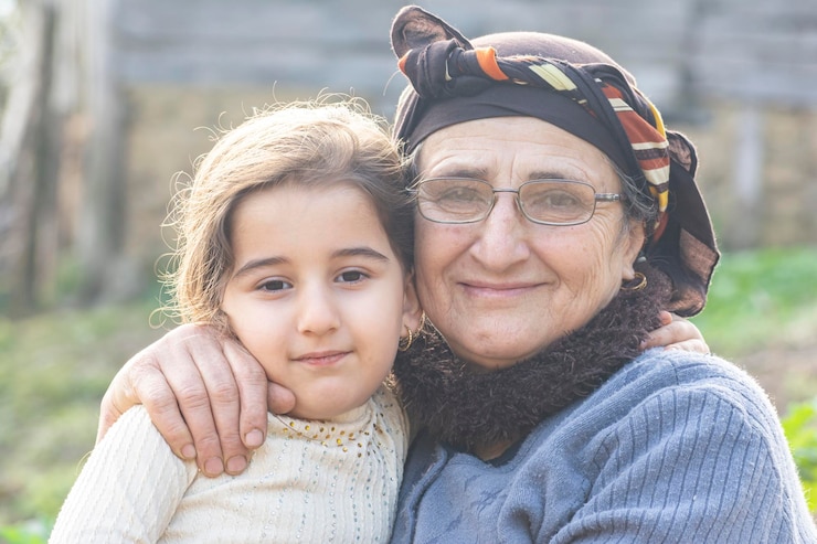 Foto ritratto di una bambina felice con la sua nonna musulmana anziana in giardino