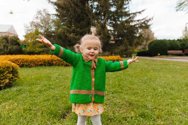 Ritratto di una bambina felice in abiti autunnali. il bambino ride sullo sfondo della natura.