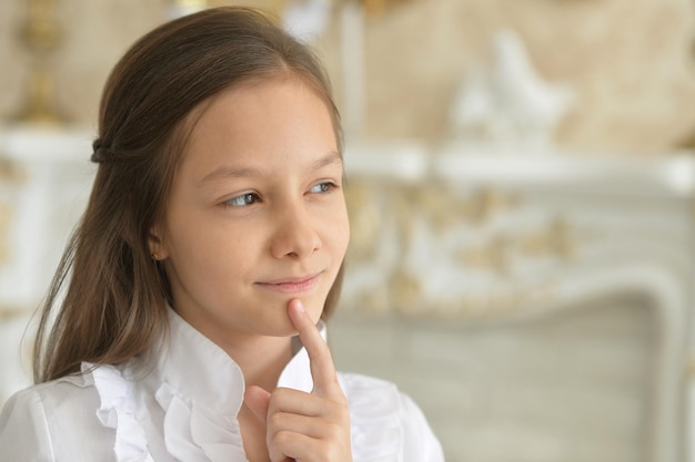 Ritratto di una bambina in camicetta bianca in posa