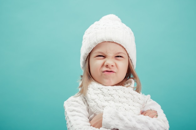 Ritratto di una bambina in cappello bianco e sciarpa