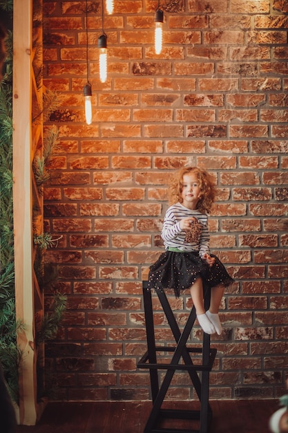 Ritratto di una bambina su uno sfondo di muro di mattoni