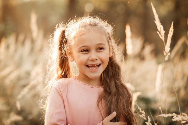 Ritratto di una bambina sullo sfondo del parco autunnale.