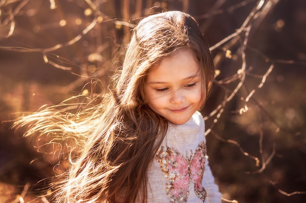 Ritratto di una bella bambina con i capelli lunghi nei boschi sulla natura