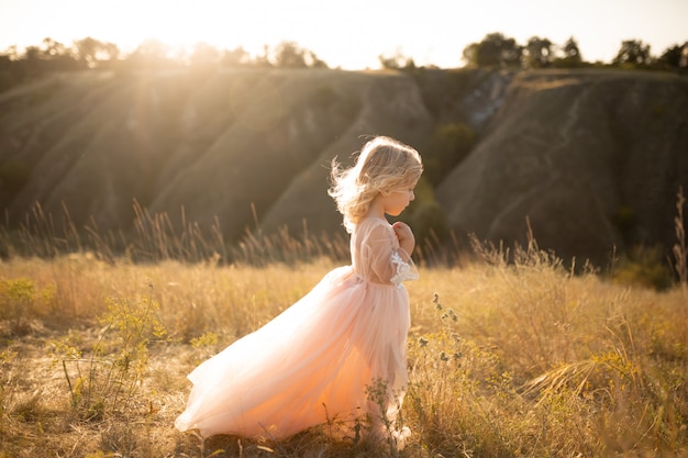 Ritratto di una bella bambina principessa in un abito rosa.