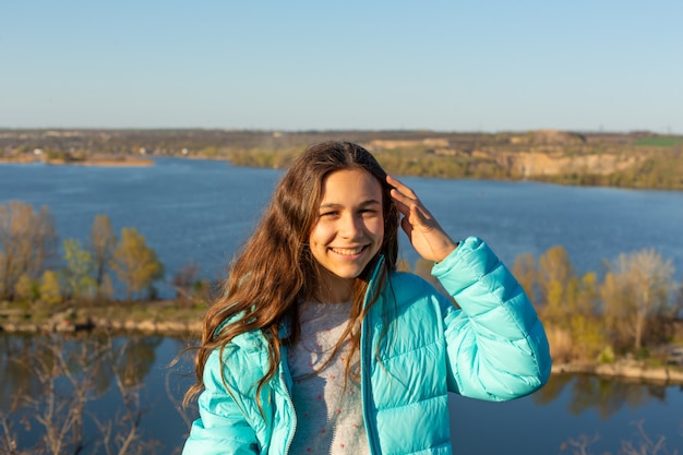 Ritratto di una bella donna adolescente sorridente su un lago.