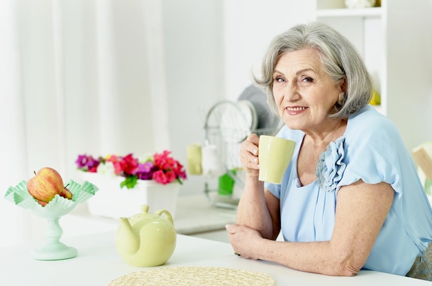 Ritratto di una bella donna anziana felice con una tazza di tè