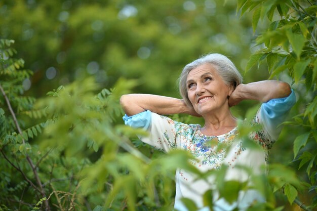 Ritratto di una bella donna anziana in un parco verde