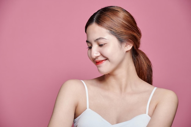 Ritratto di una bella donna asiatica con la pelle giovane, pulita e sana scattato in studio su uno sfondo rosa isolato
