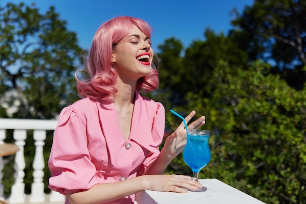 Ritratto di una bella donna che beve un cocktail sulla terrazza una donna felice che si rilassa foto di alta qualità