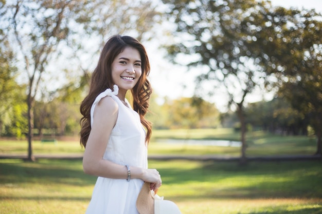 Ritratto di una bella donna con abito bianco in giardino