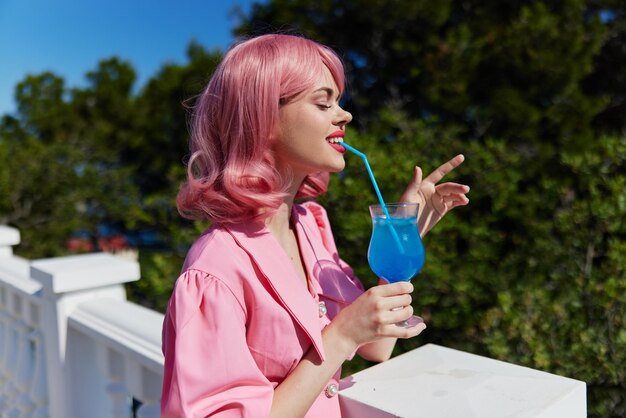 Ritratto di una bella donna con i capelli rosa cocktail estivo bevanda rinfrescante donna felice rilassante foto di alta qualità