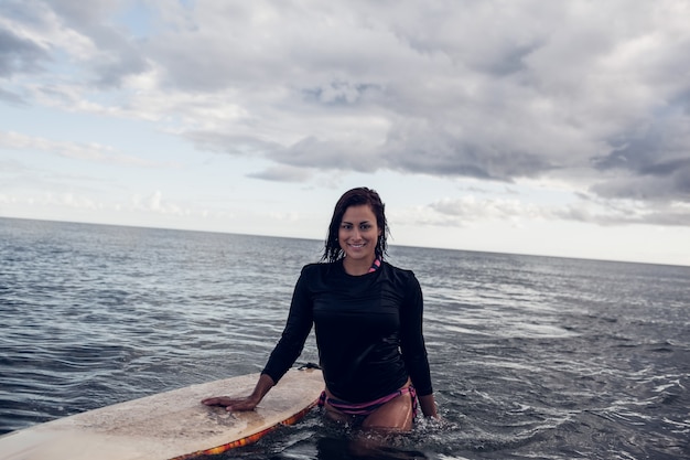 Ritratto di una bella donna con tavola da surf in acqua