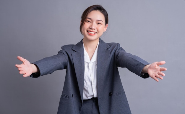 Ritratto di una bella donna d'affari asiatica su sfondo grigio