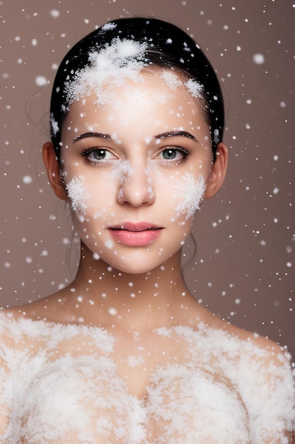 Ritratto di una bella donna e neve sul viso Trucco invernale come una regina delle nevi