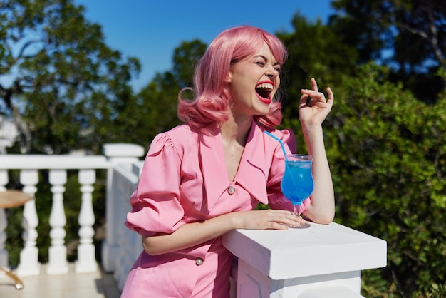 Ritratto di una bella donna in abito rosa all'aperto con un cocktail giorno d'estate foto di alta qualità