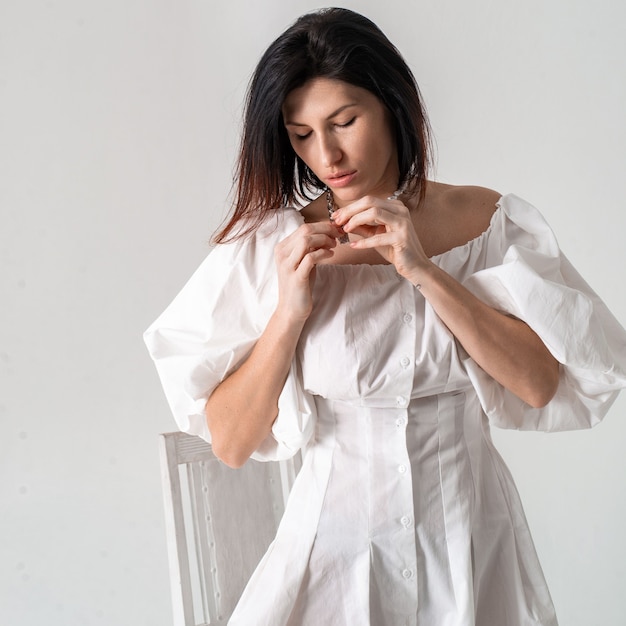 Ritratto di una bella donna in bianco con una collana