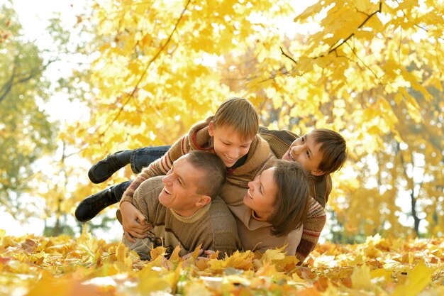 Ritratto di una bella famiglia felice sdraiata nel parco autunnale