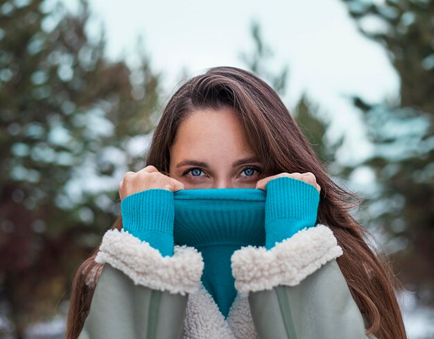 Ritratto di una bella giovane donna bruna nel parco invernale