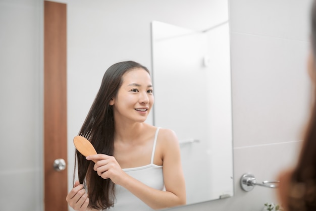 Ritratto di una bella giovane donna che pettina i suoi capelli