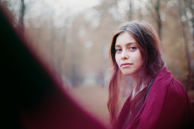 Ritratto di una bella giovane donna in giacca nera in autunno