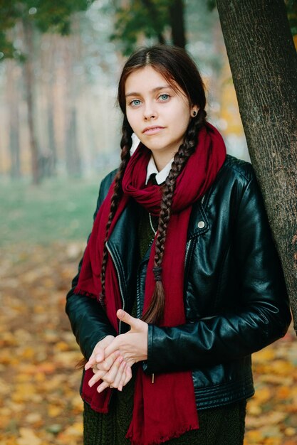 Ritratto di una bella giovane donna in giacca nera in autunno
