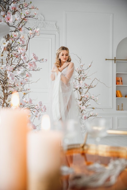 ritratto di una bella giovane sposa in un abito da sposa bianco in un interno chic