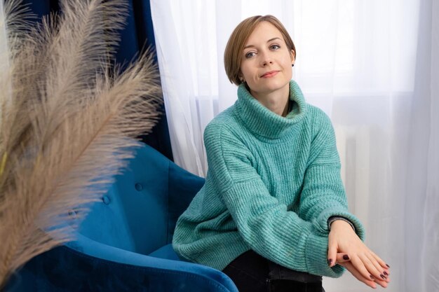 Ritratto di una bella psicologa o consulente femminile seduta su una sedia in un ufficio di terapia
