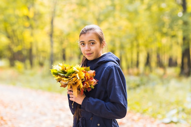 Ritratto di una bella ragazza adolescente in foglie di autunno