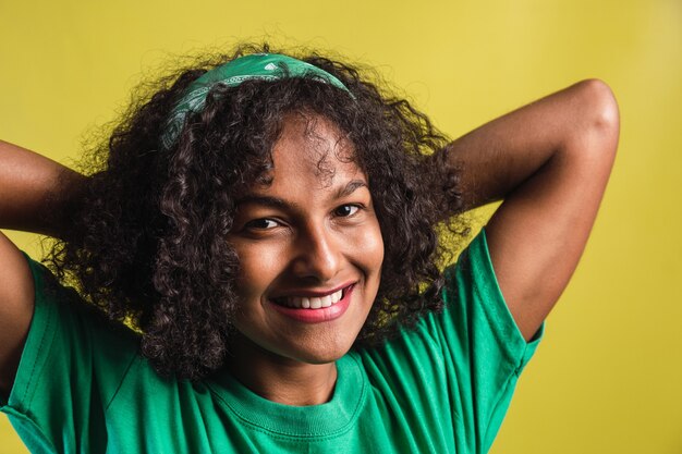 Ritratto di una bella ragazza afro sorridente con i riccioli.