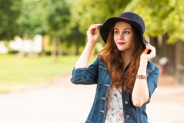 Ritratto di una bella ragazza alla moda con cappello all'aperto in giornata estiva