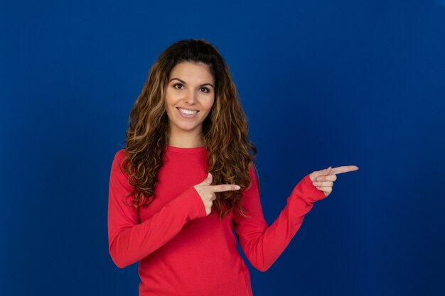 Ritratto di una bella ragazza caucasica con capelli ricci isolato su un muro bianco