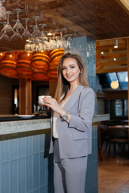 Ritratto di una bella ragazza che beve un delizioso caffè in una bella caffetteria moderna Serve caffè e bevande nel ristorante e nella caffetteria