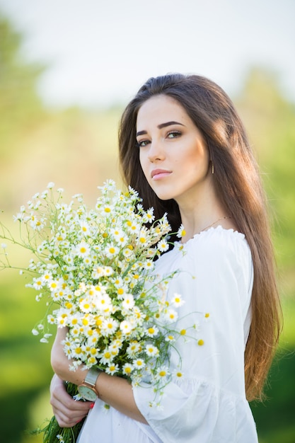 Ritratto di una bella ragazza con bouquet, all'aperto, nel campo