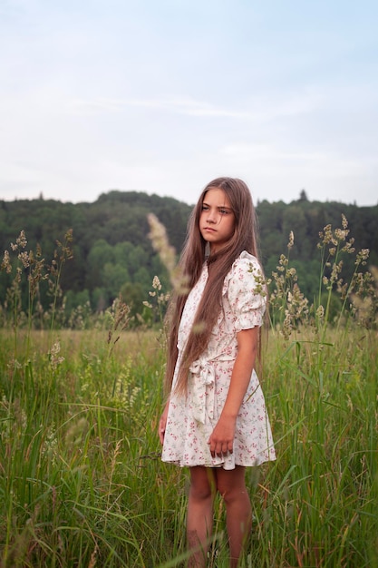 Ritratto di una bella ragazza con i capelli lunghi in un campo estivo