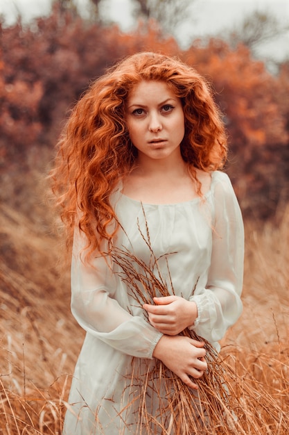 Ritratto di una bella ragazza con i capelli rossi in campo