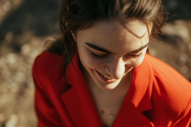 Ritratto di una bella ragazza con un cappotto rosso sulla natura