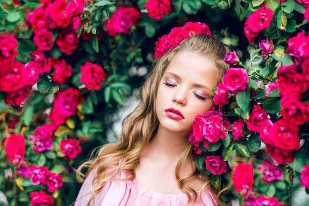 Ritratto di una bella ragazza in fiori di rosa