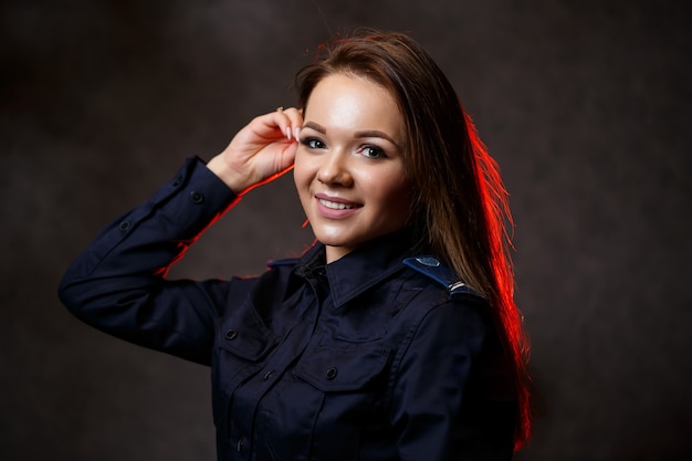 Ritratto di una bella ragazza in uniforme della polizia. Posa professionale