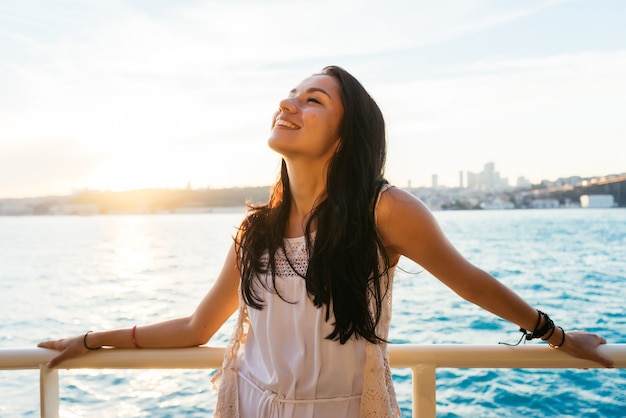 Ritratto di una bella ragazza latina su uno yacht al tramonto e ride, un viaggio in traghetto, un viaggio di lusso a Istanbul