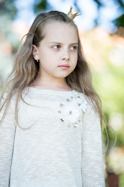 Ritratto di una bella ragazza principessa carina felice con lunghi capelli ricci biondi al giorno di sole estivo