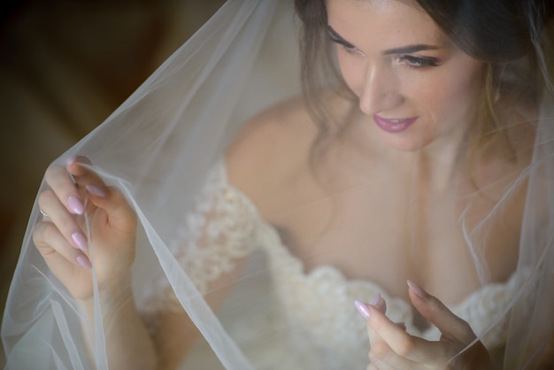 Ritratto di una bella sposa sotto un velo.