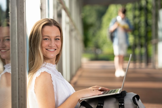 Ritratto di una bella studentessa che lavora al computer portatile