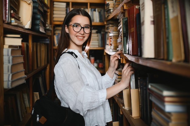 Ritratto di una bella studentessa in una biblioteca