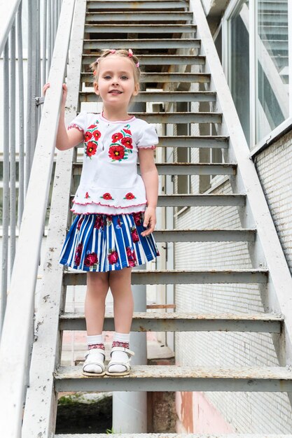 Ritratto di una bellissima bambina ricamata su una vecchia scala di metallo