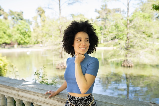 Ritratto di una bellissima donna afroamericana che sorride e guarda il parco