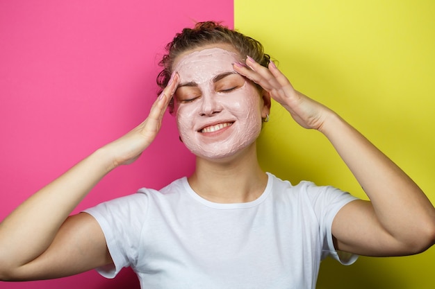 Ritratto di una bellissima ragazza che si mette una maschera rinfrescante sul viso per ringiovanire e tonificare la pelle. Trattamenti di bellezza